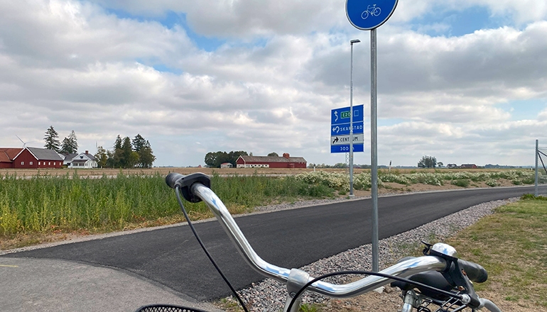Cykel står vid en nyligen asfalterad cykelväg. 