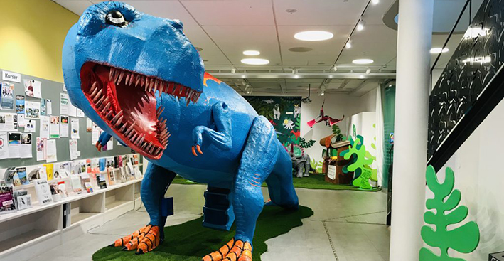 En blå dinusaurie på biblioteket